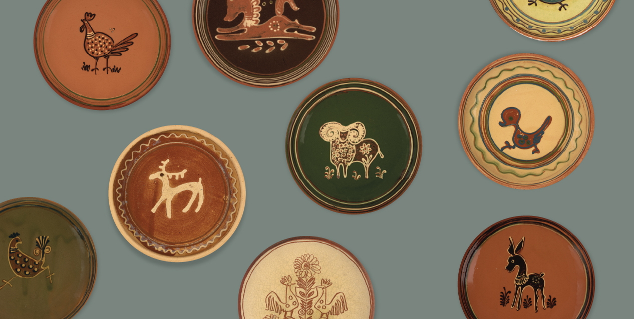 Kilka okrągłych ceramicznych talerzy ułożonych nieregularnie na szaro‑zielonym tle, każdy w innym ziemistym kolorze (ceglasty, brązowy, zielony, kremowy) z ręcznie malowanymi, stylizowanymi motywami zwierzęcymi — ptaków, jelenia, barana, kaczki i zająca.